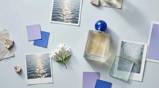 Perfume reference board with a blue-capped glass bottle, colour swatches, jasmine and lighting photographs.